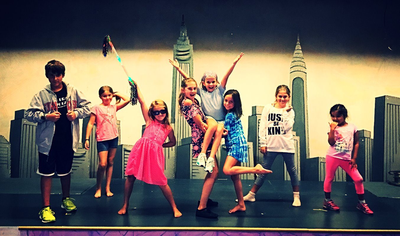 Campers striking poses in front of a city skyline set