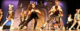 A dance number in front of a castle set