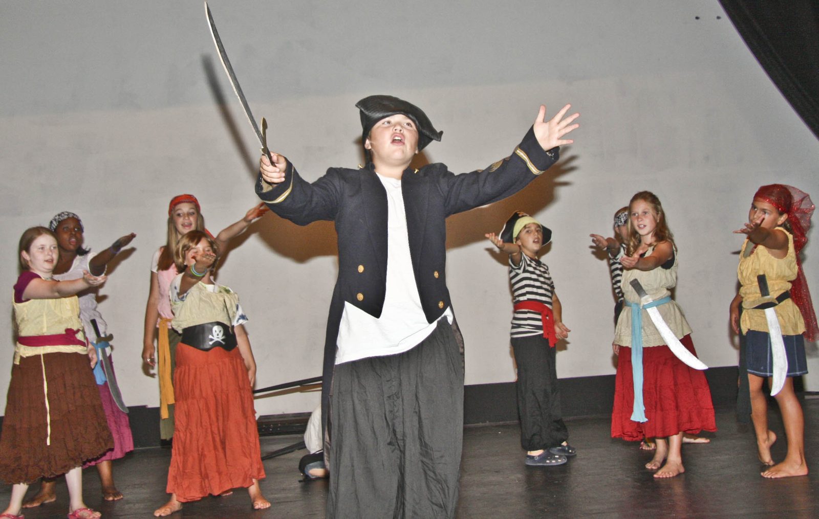 A pirate captain and crew on stage